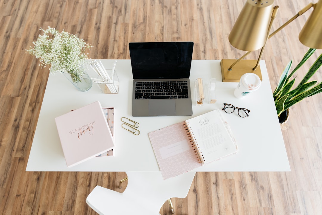 Home office desk with laptop, notebook, and coffee cup